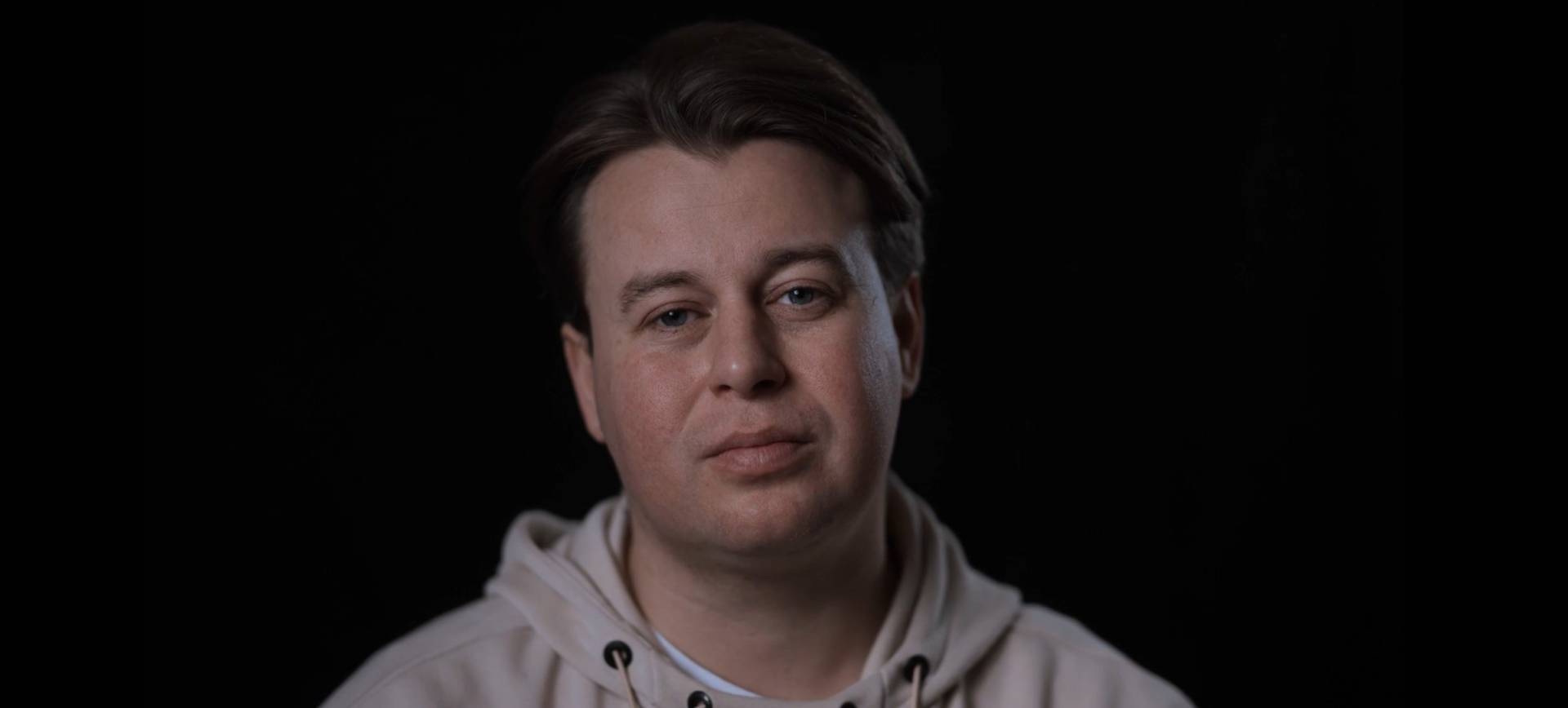 Man talking to a camera with a black background