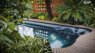 Outdoor jacuzzi surrounded by garden plants to show campaign video services